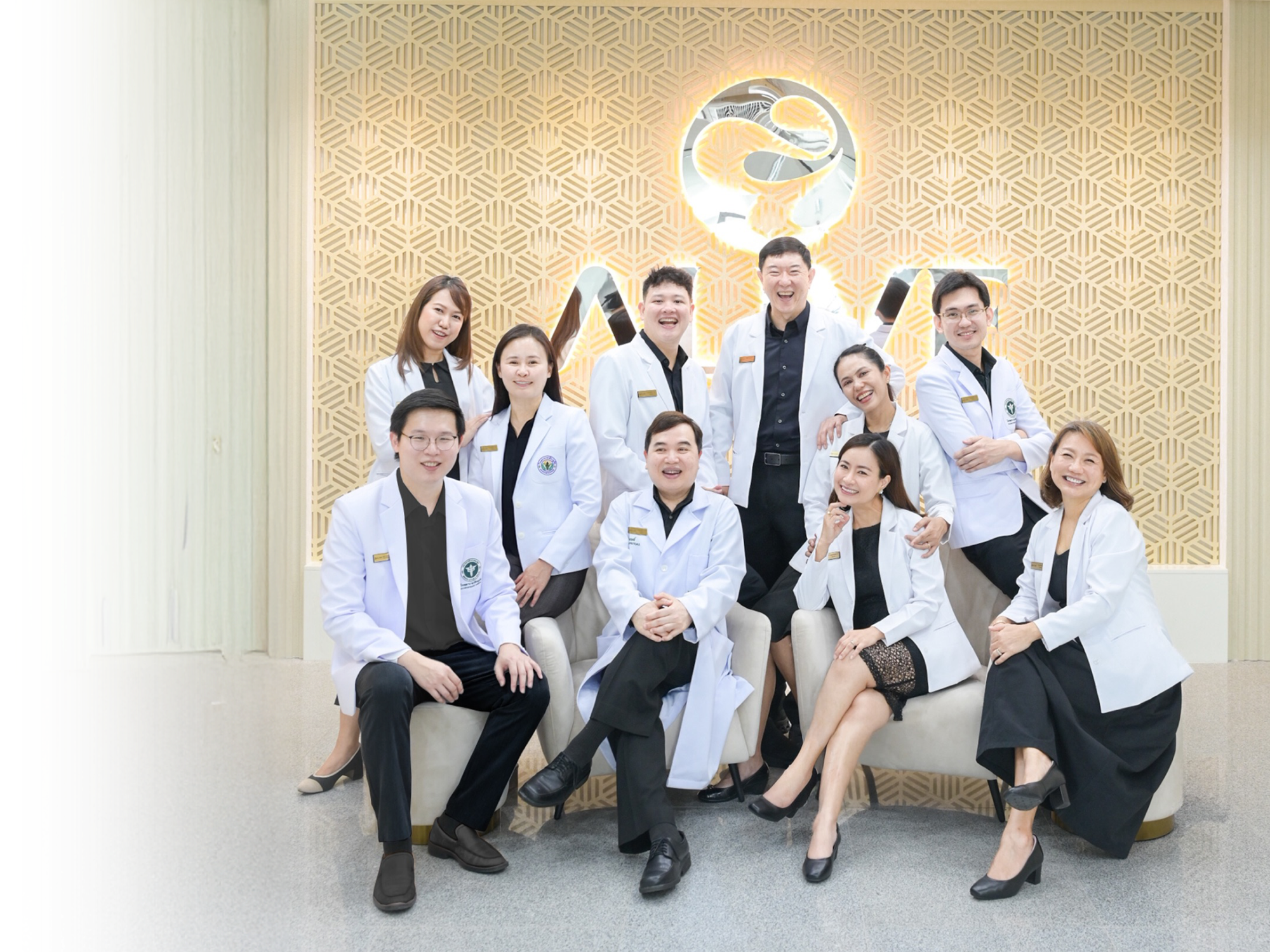 ALIVE clinic medical team — eleven doctors and staff seated together in front of the ALIVE wall logo